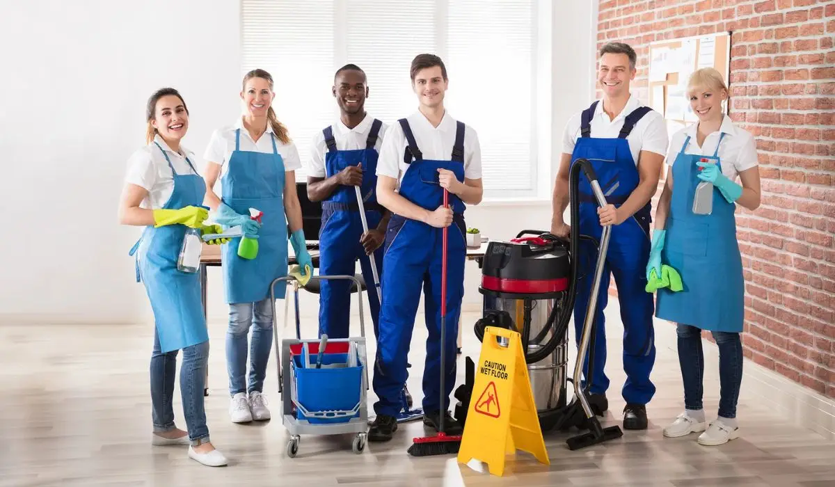 professional cleaning staff posing for a picture holding cleaning supplies
