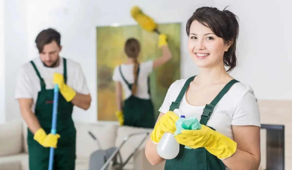 three cleaners cleaning up a room with cleaning supplies