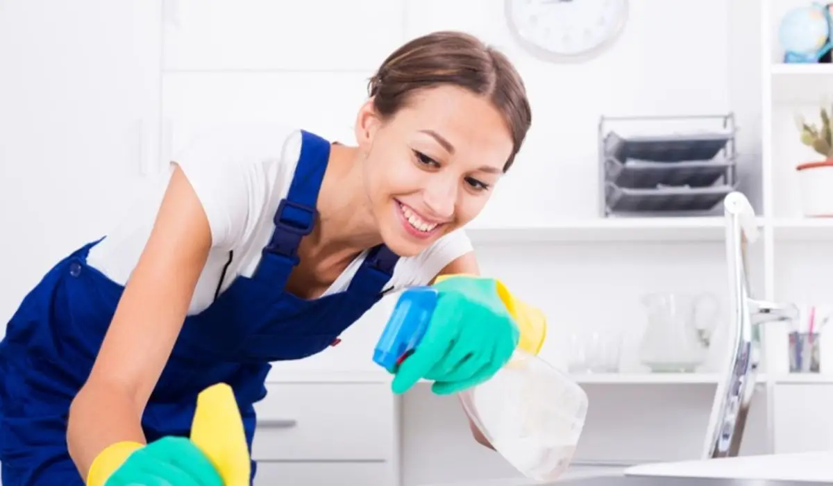 a-woman-using-a-spray-bottle-to-wipe-clean-surfaces-in-the-office