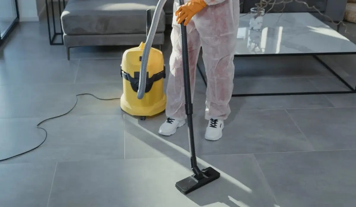 a close up shot of a person using a vacuum cleaner