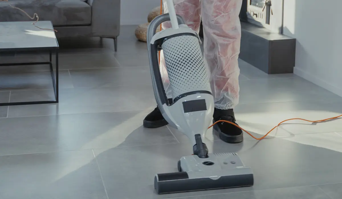 a person using a vacuum to clean the floor
