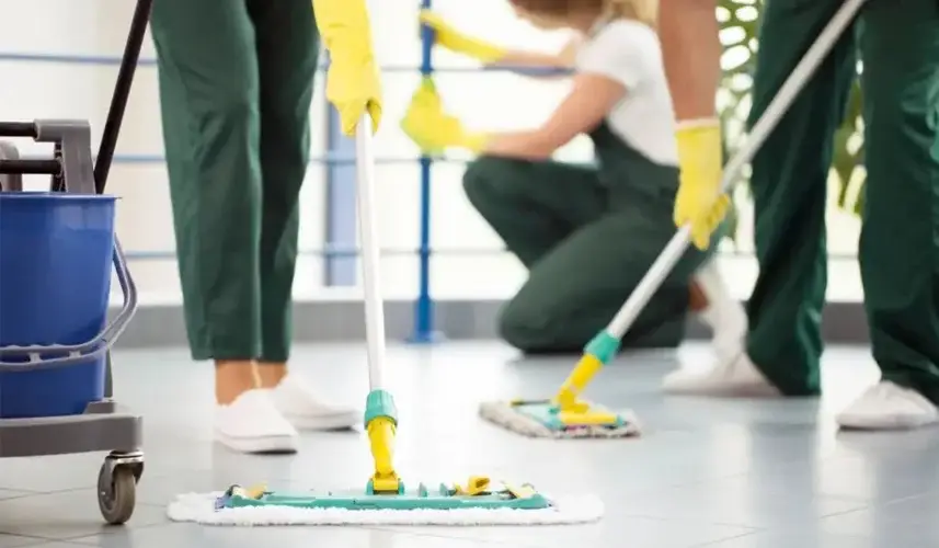 employees mopping the floor of a small office